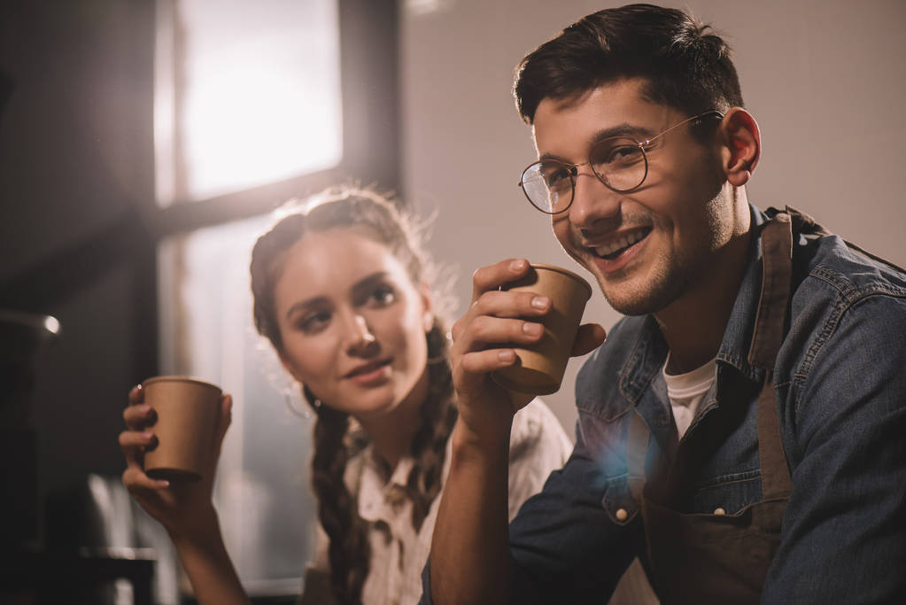 couple with cups of coffee having break during work at coffee shop - Photo, Image