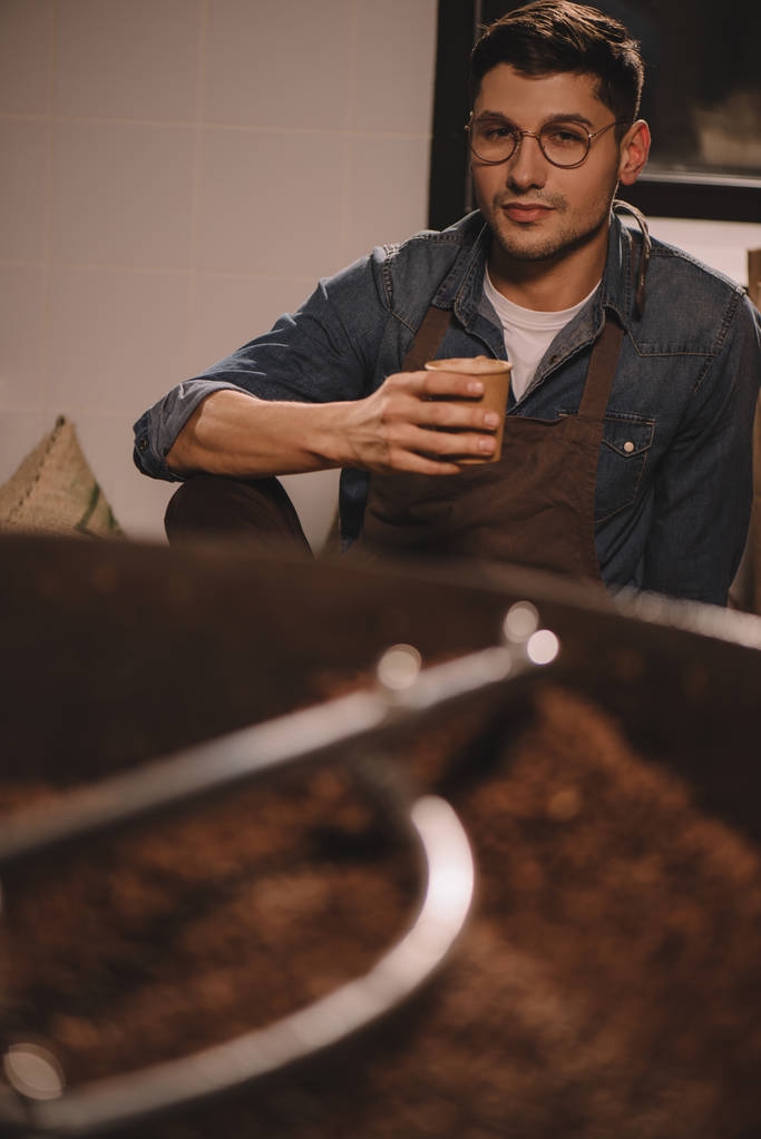 πορτρέτο του συλλογισμένος καφέ ρόστερ με φλιτζάνι καφέ, έχοντας σπάσει κατά τη διάρκεια εργασιών - Φωτογραφία, εικόνα