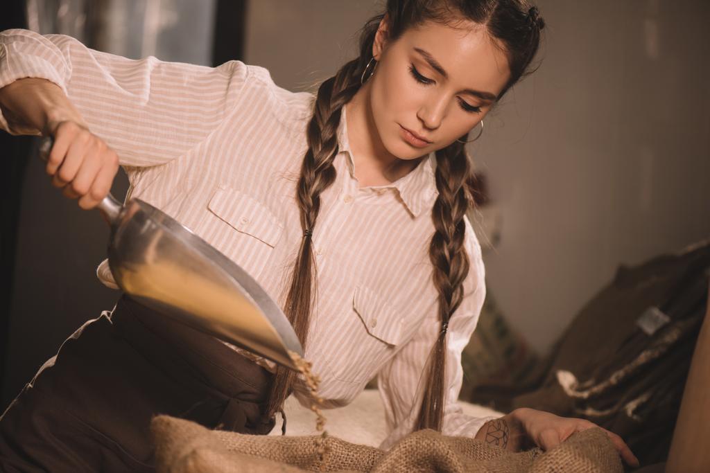портрет робітника, що вливає кавові зерна в мішок
 - Фото, зображення