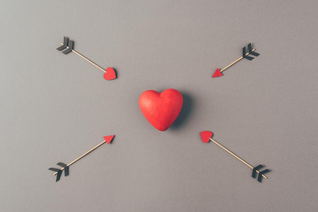 gri dört ok arasında kırmızı kalp üst görünümü, sevgililer günü kavramı - Fotoğraf, Görsel