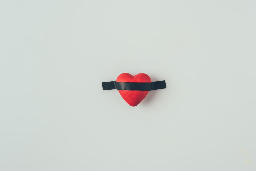 vista superior del corazón rojo bajo cinta aislante aislada en blanco, concepto de día de San Valentín
 - Foto, imagen