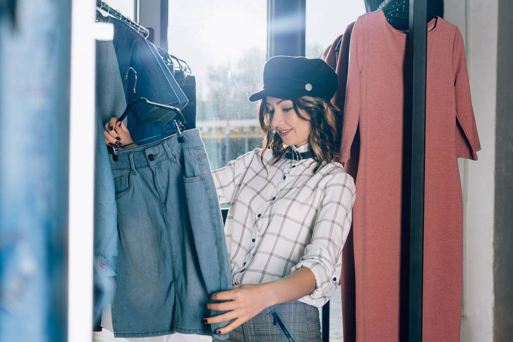 όμορφη νεαρή γυναίκα που ψάχνει για νέα ρούχα στο κατάστημα - Φωτογραφία, εικόνα