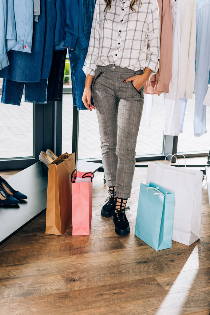 oříznutý snímek stylové ženy s nákupní tašky v obchod s oblečením - Fotografie, Obrázek
