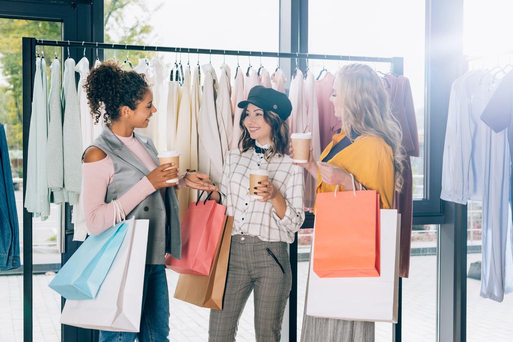 grupo de mujeres jóvenes con bolsas de compras y café para ir a la tienda de ropa
 - Foto, Imagen