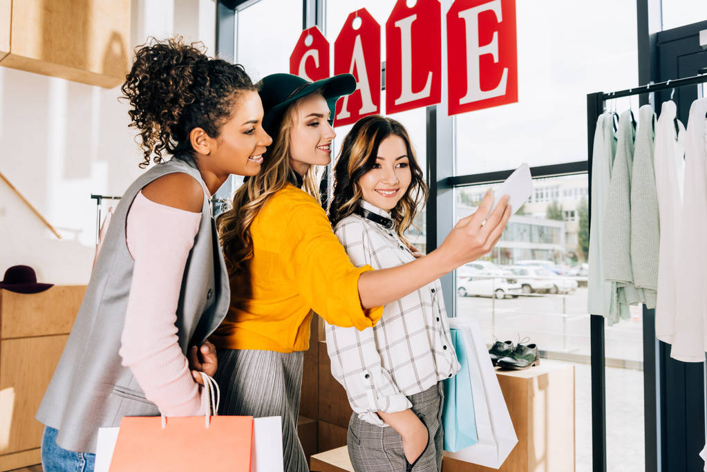 grupo de mujeres jóvenes multiétnicas tomando selfie en las compras
 - Foto, Imagen
