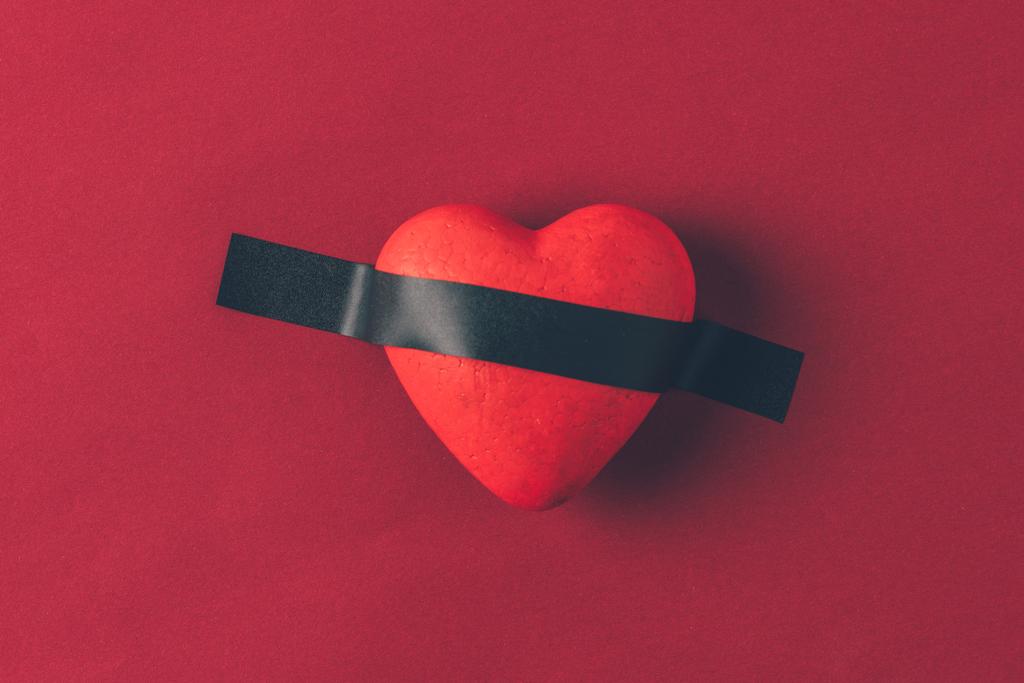 vista superior del corazón rojo bajo cinta aislante en el concepto rojo, día de San Valentín
 - Foto, Imagen