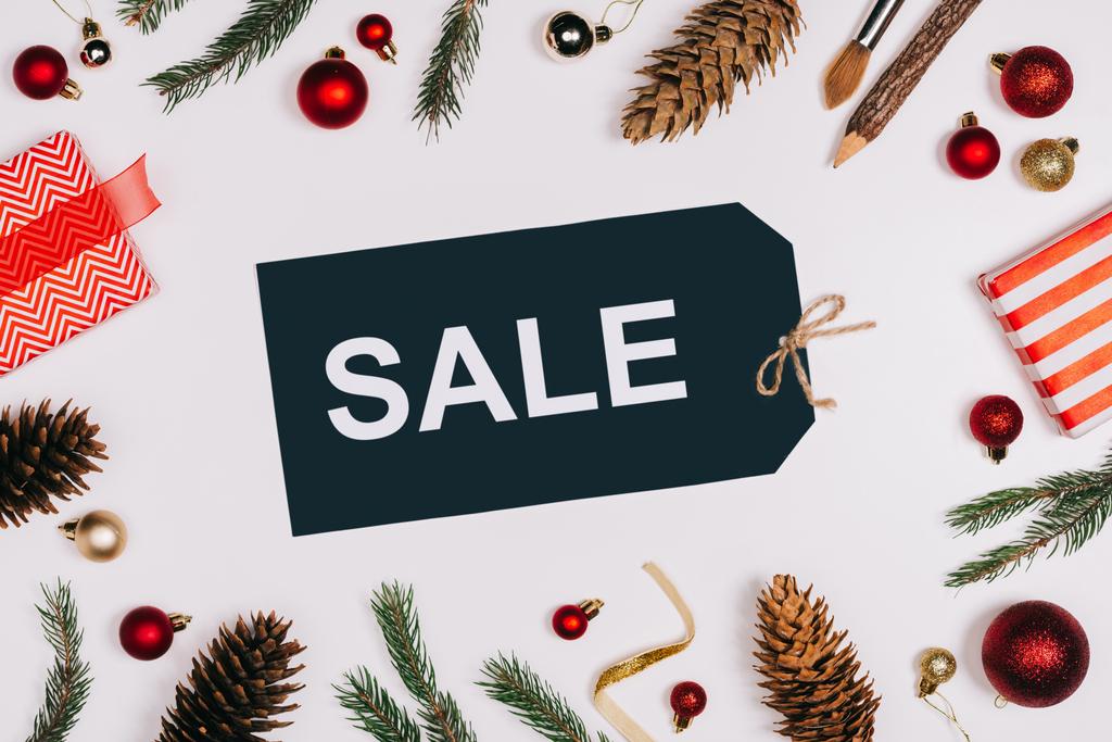 düz lay görücü usulü fiyat etiketi ile satış harflerle, çam kozalakları, sarılmış hediyeler ve üzerinde beyaz izole Noel oyuncaklar ile  - Fotoğraf, Görsel