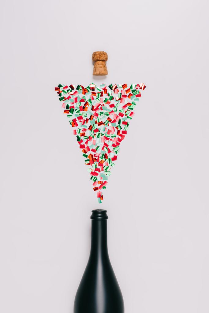 κάτοψη του μπουκαλιού και τοποθετημένα φελλού με πολύχρωμα κομφετί σε χριστουγεννιάτικο δέντρο που απομονώνονται σε λευκό - Φωτογραφία, εικόνα