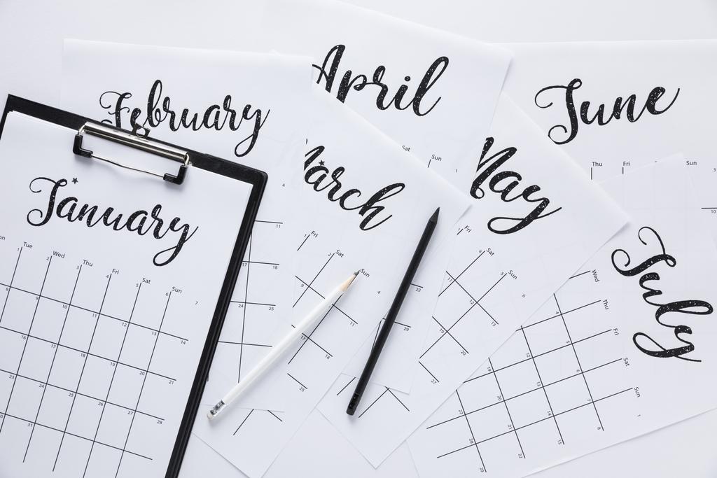 leigos planos com calendário, bloco de notas e lápis isolados em branco
 - Foto, Imagem