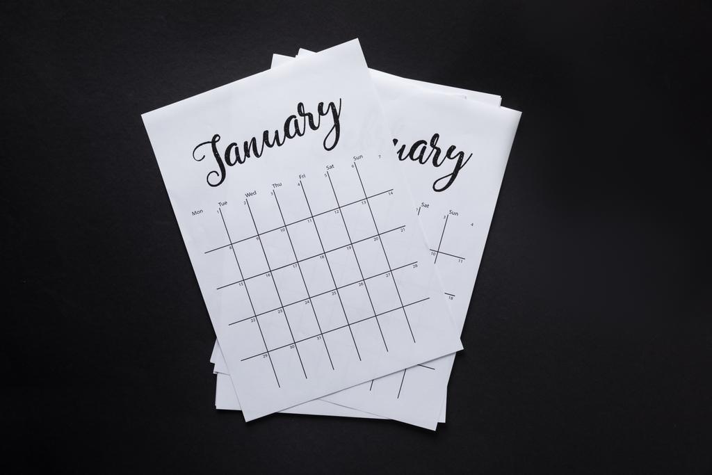 верхний вид упорядоченных частей бумажного календаря, изолированных на черном
 - Фото, изображение