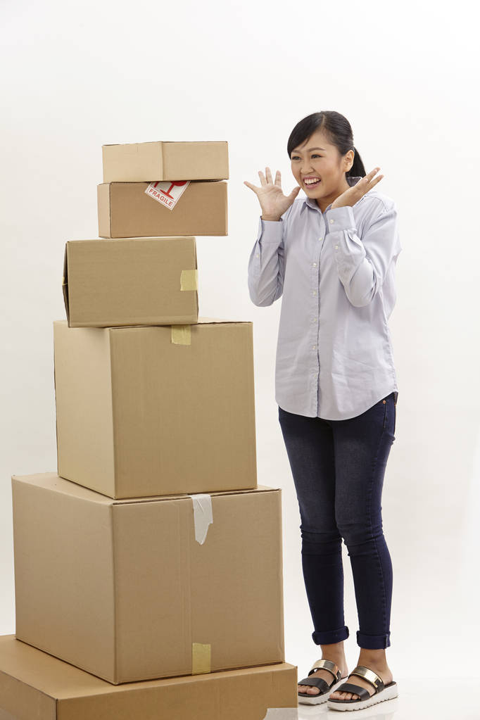 азиатка со стопкой коробок на белом фоне
 - Фото, изображение