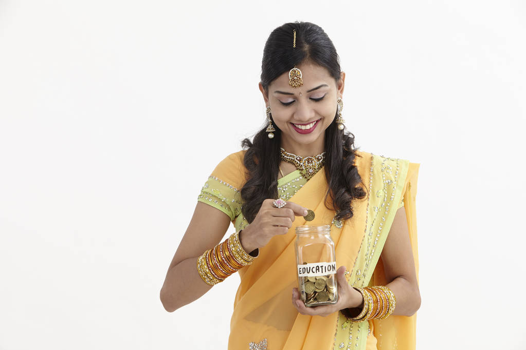 Indiase vrouw in glamoureuze traditionele kleding houden een opslaan pot  - Foto, afbeelding