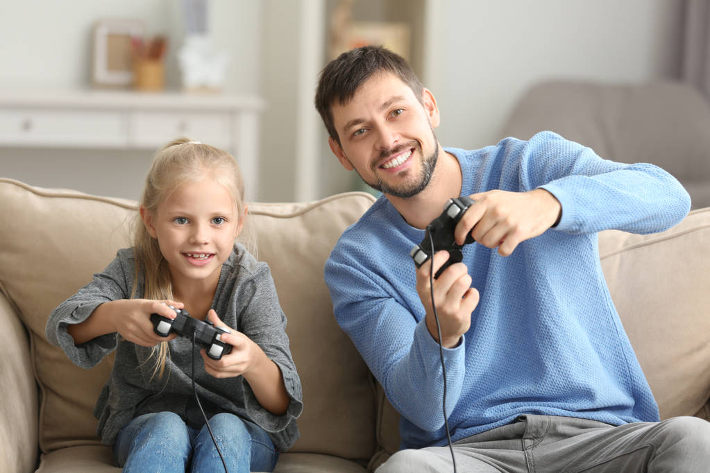 Père et sa petite fille jouent au jeu vidéo à la maison
 - Photo, image