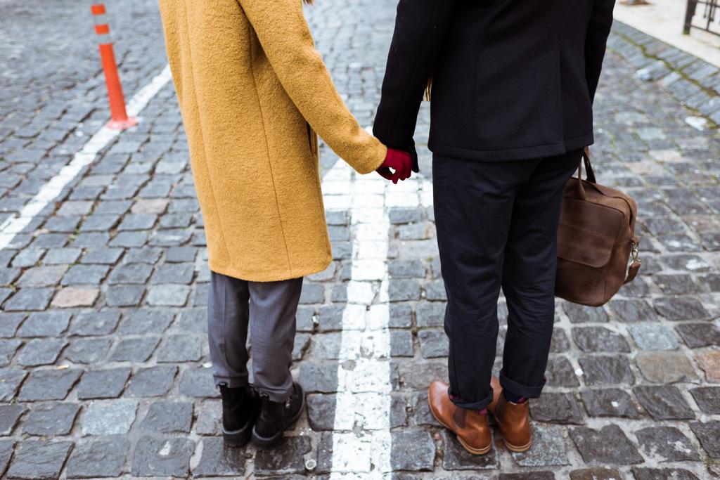 oříznutý obraz páru v podzimní oblečení, drželi se za ruce - Fotografie, Obrázek