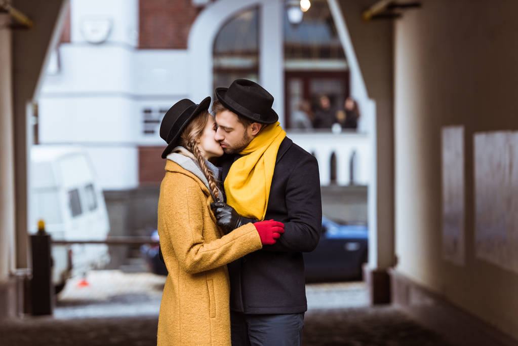νεαρό ζευγάρι στο Φθινοπωρινό ντύσιμο αγκάλιασμα και το φίλημα - Φωτογραφία, εικόνα