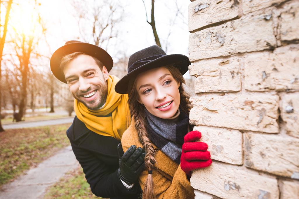 cheerful young couple in autumn outfit looking at corner - Photo, Image