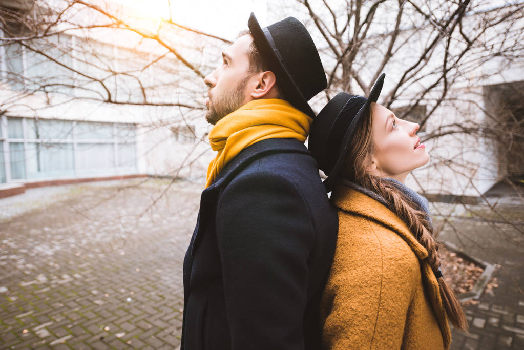 mladý atraktivní pár stojící zády k sobě před budovy - Fotografie, Obrázek