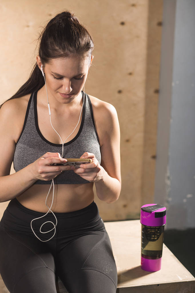 Atleet gebruik mobiele telefoon app fitness tracker voor het bijhouden van gewicht verlies vooruitgang - Foto, afbeelding