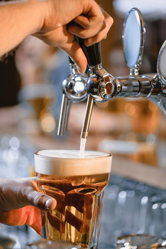 immagine ritagliata di barman versando birra in vetro al bar
 - Foto, immagini