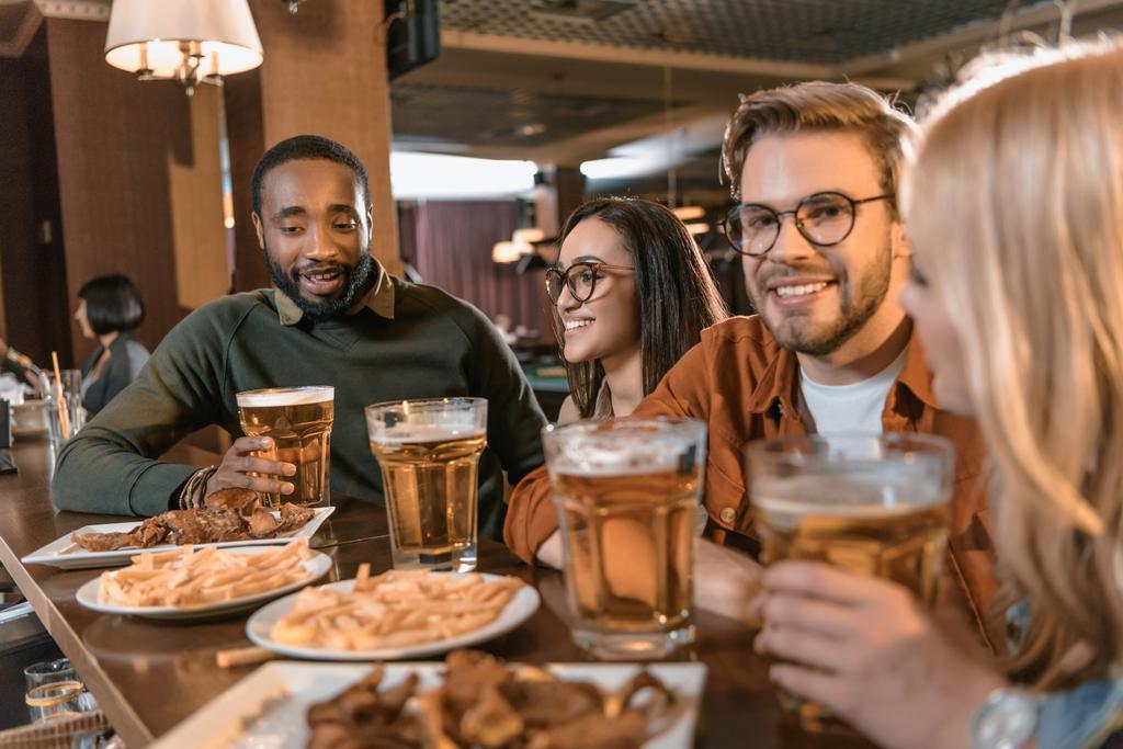 joven empresa multicultural comer y beber en el bar
 - Foto, imagen