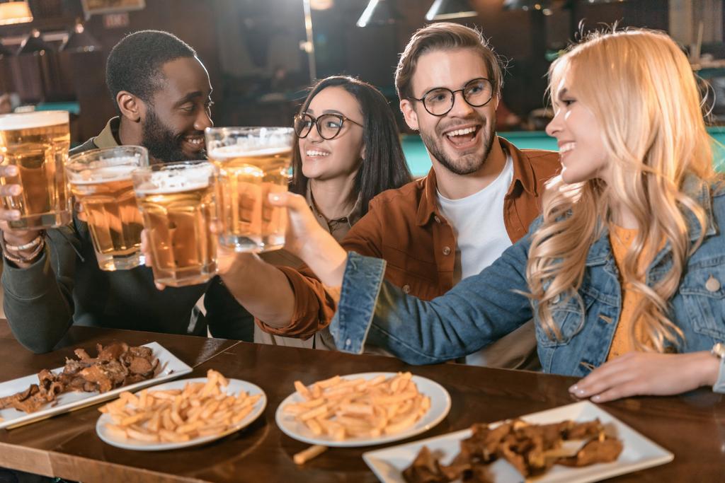 νέοι multiculture εταιρεία τρώγοντας και πίνοντας σε μπαρ - Φωτογραφία, εικόνα