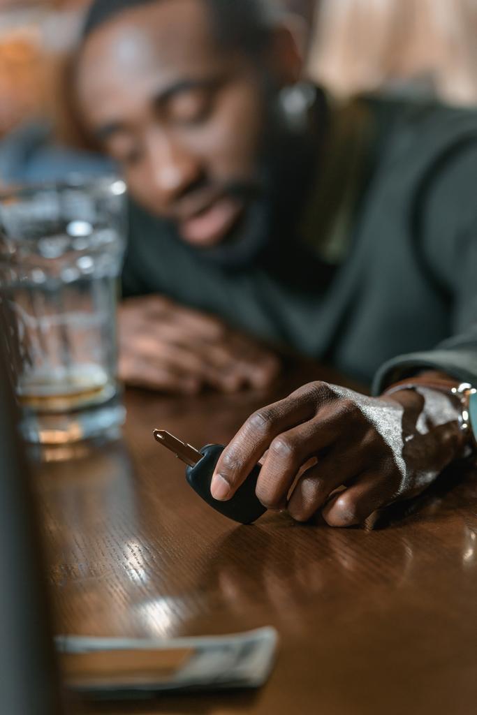 homem americano africano muito bêbado com chaves de automóvel no bar
 - Foto, Imagem