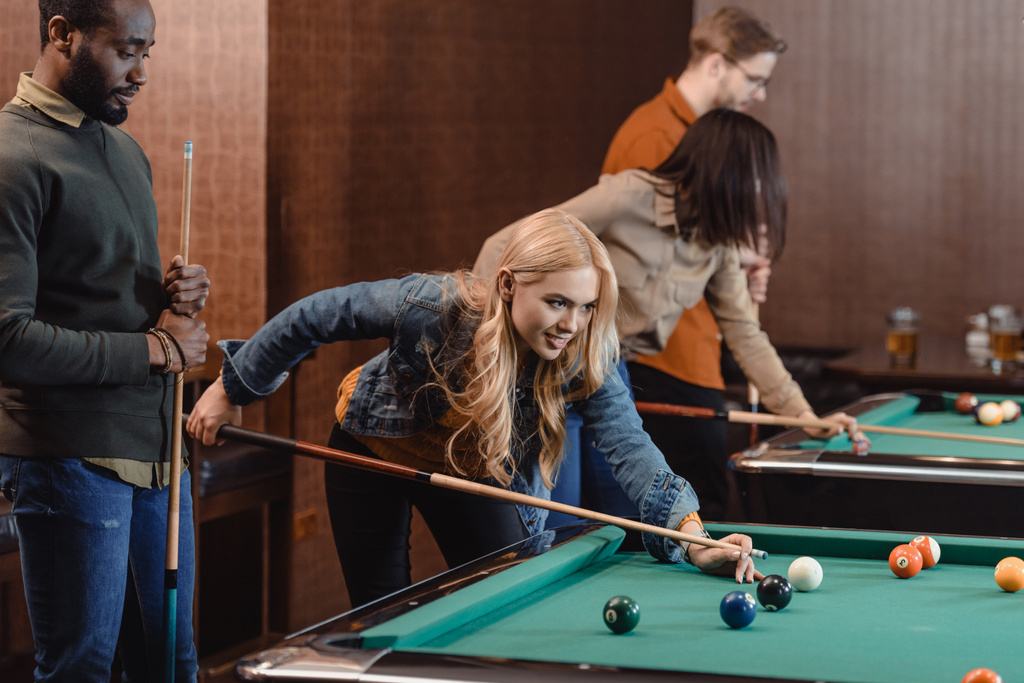 young attractive multiculture friends playing in pool at bar - Photo, Image