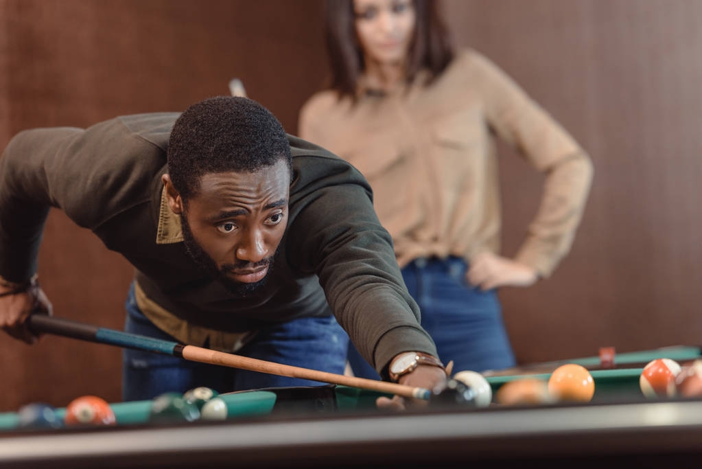 Afrikanisch-amerikanischer Mann spielt in Pool an Bar - Foto, Bild