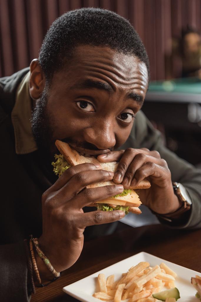 homme afro-américain manger un sandwich au bar
  - Photo, image