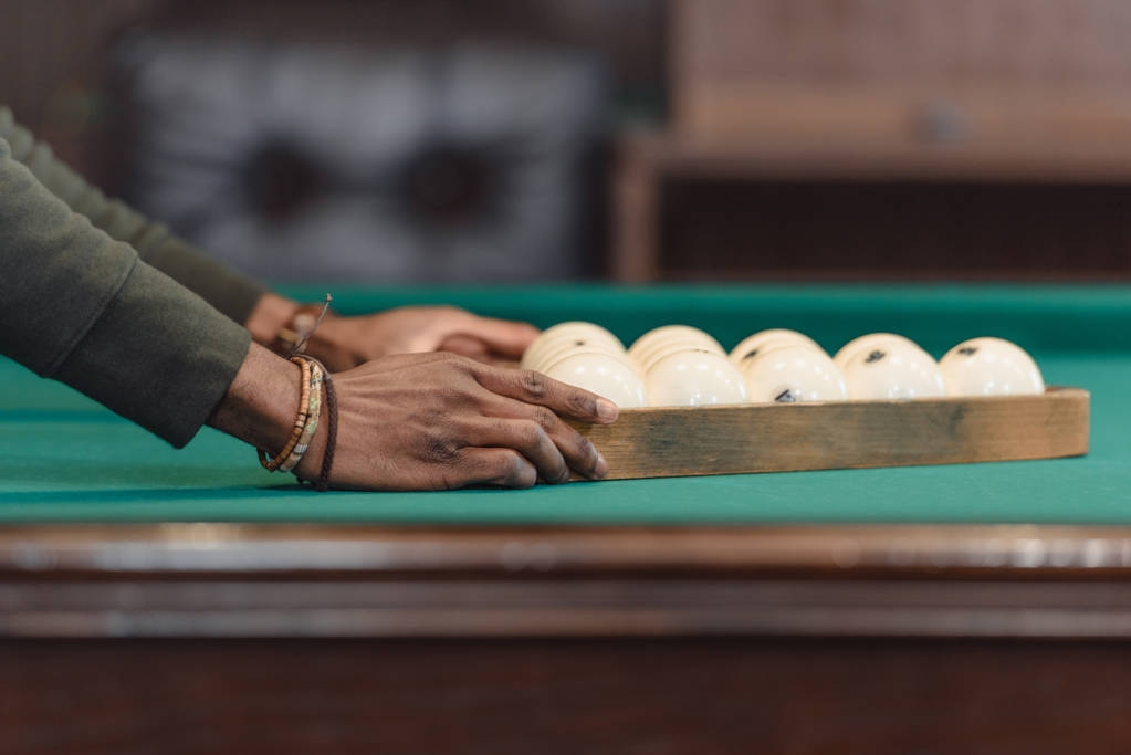 ボール プール ギャンブル テーブルの上の三角形で設定を形成する男性の手の画像をトリミング  - 写真・画像
