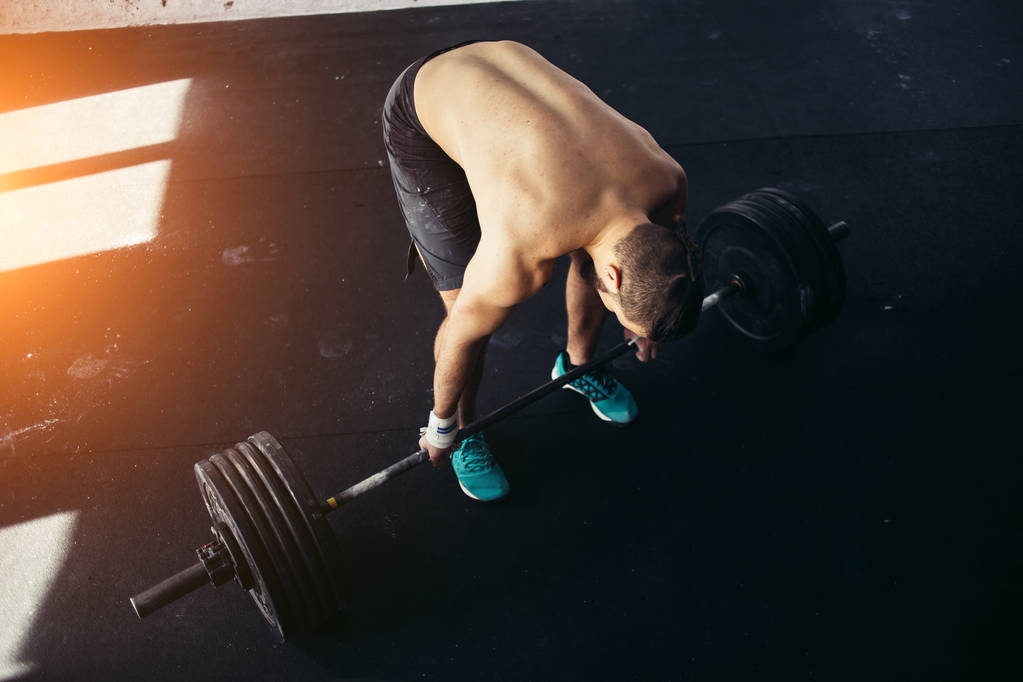 hombre levantando pesas. entrenamiento de hombre muscular en el gimnasio haciendo ejercicios con barra
 - Foto, imagen