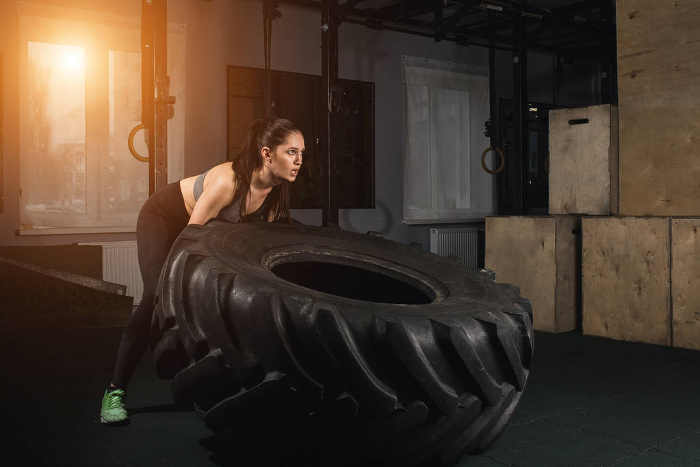 female flipping tire at the gym. - Photo, Image