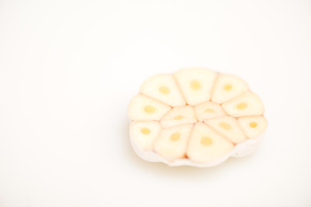 kesilmiş parça üzerinde beyaz izole sarımsak görünümünü kapat - Fotoğraf, Görsel