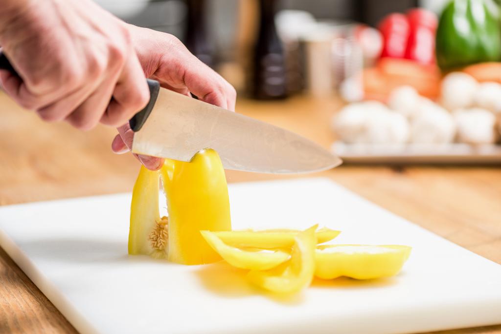 cropped image of chef cutting yellow bell pepper - Photo, Image