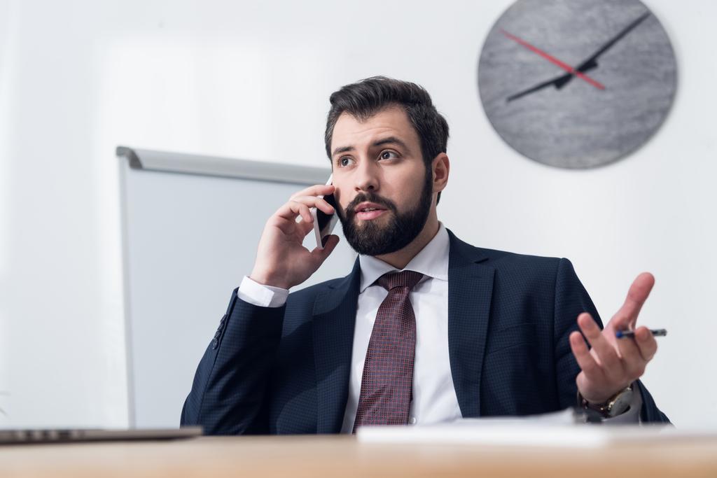 retrato de jovem empresário falando no smartphone no local de trabalho no escritório
 - Foto, Imagem