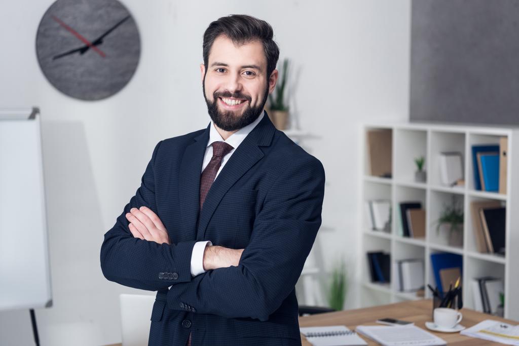 retrato de un hombre de negocios sonriente con los brazos cruzados en la oficina
 - Foto, imagen
