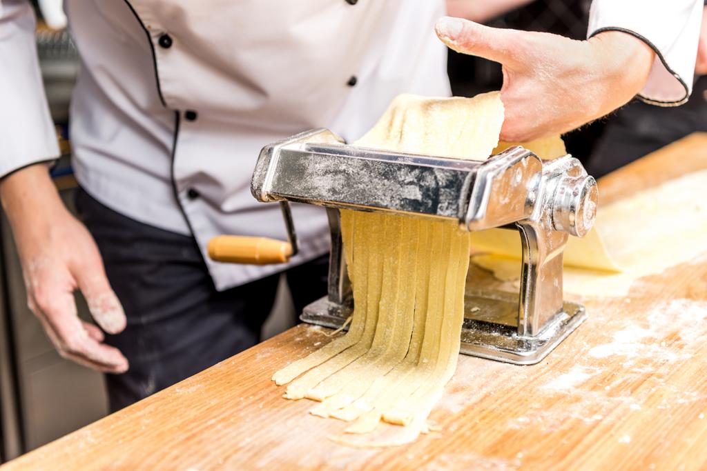 imagen recortada de chef haciendo pasta con fabricante de pasta
 - Foto, Imagen
