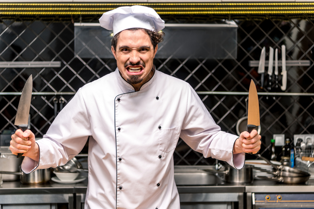 chef che sghignazza e tiene in mano due coltelli
 - Foto, immagini