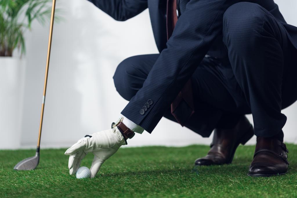ビジネスマンのスーツとオフィスでプレーするゴルフ グローブのクロップ撮影 - 写真・画像