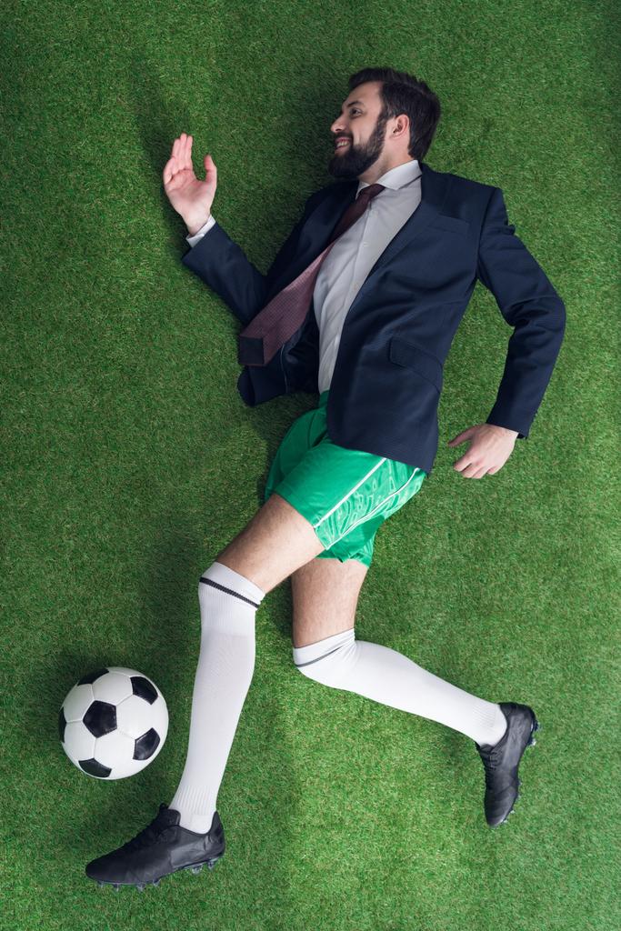 вид зверху бізнесмена, який грає у футбол на зеленому газоні
 - Фото, зображення
