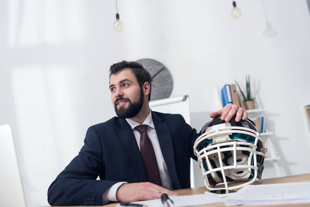 joven empresario con casco de rugby en el lugar de trabajo en la oficina
 - Foto, imagen