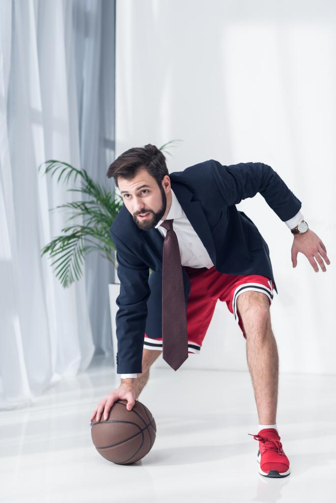 uomo d'affari in giacca e pantaloncini che gioca a basket in ufficio
 - Foto, immagini