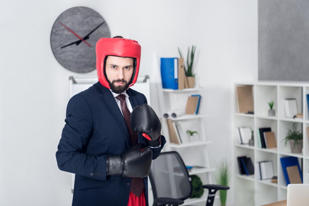 portrait of young businessman in boxing equipment in office - Photo, Image