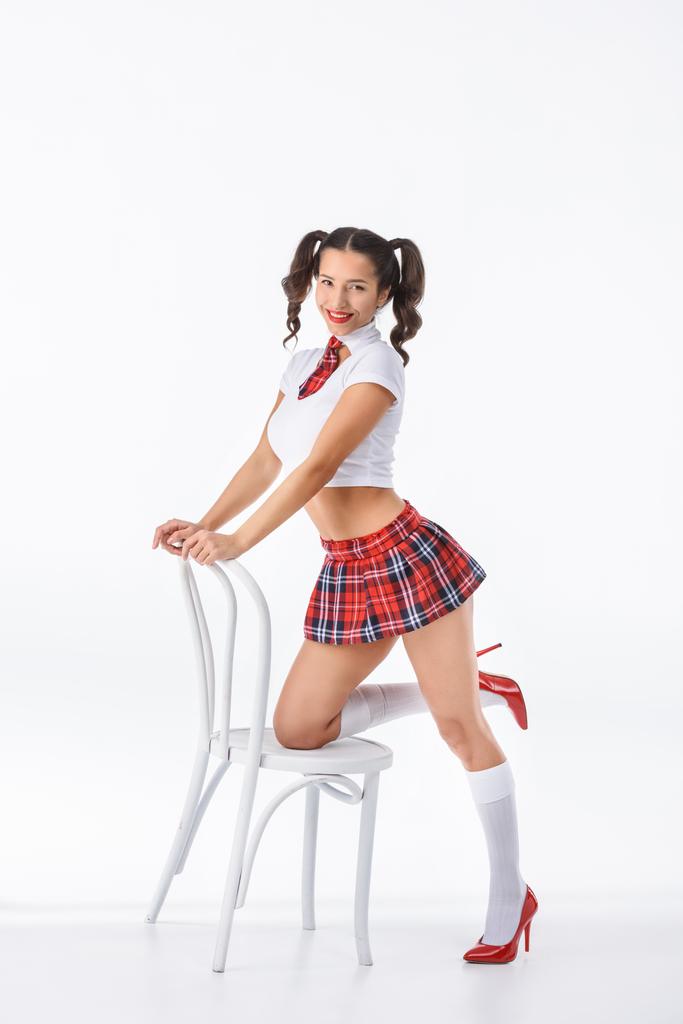 young sexy schoolgirl with vintage white chair isolated on white - Photo, Image