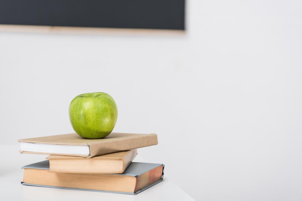 a halmozott könyvek a tantermi zöld alma - Fotó, kép