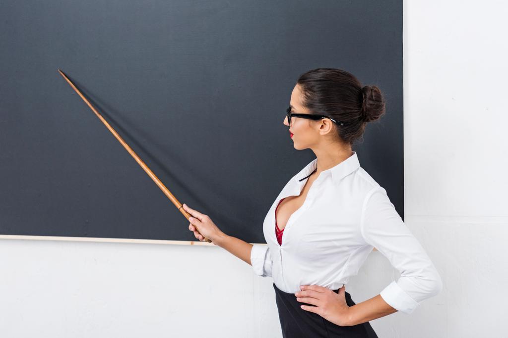 fiatal gyönyörű tanár mutatva chalkboard - Fotó, kép