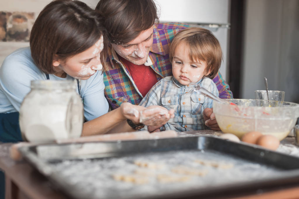 belle jeune famille préparant des biscuits ensemble à la cuisine
 - Photo, image