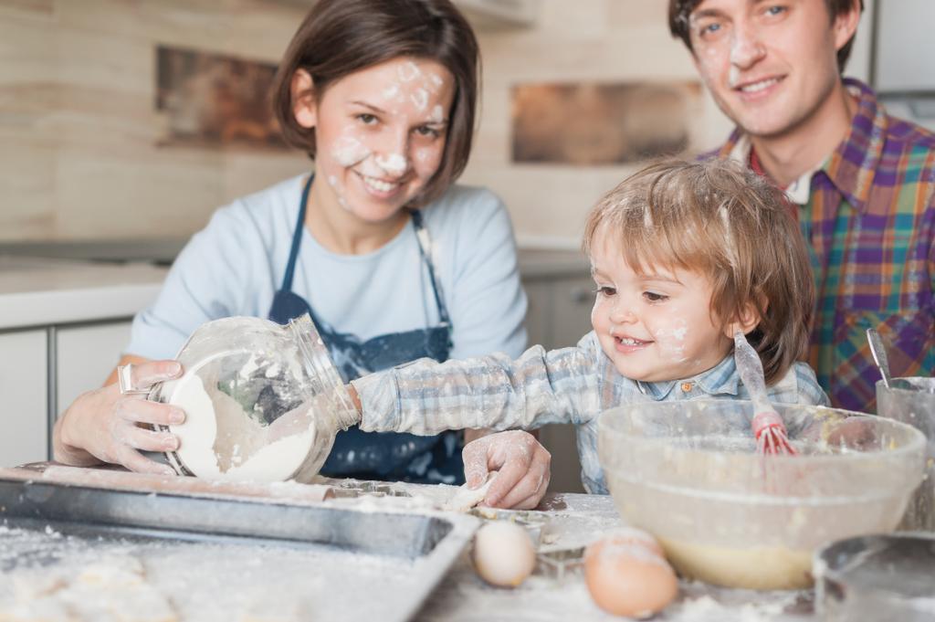 urocze małe dziecko pomoc rodziców z gotowania w kuchni - Zdjęcie, obraz