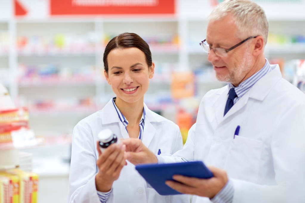 аптекари с планшетным ПК и лекарством в аптеке
 - Фото, изображение
