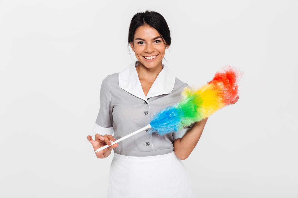 Portrait of pretty smiling woman in uniform holding colorful dus - Photo, Image
